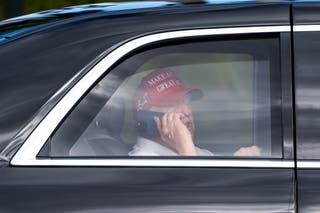 President Donald Trump talks on the phone while arriving at the Trump International Golf Club, Friday, April 4, 2025, in West Palm Beach, Florida